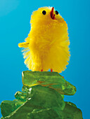 Yellow Easter Chick Standing on a Pile of Green Glass Stones