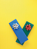 Gifts wrapped in colorful paper on yellow background, studio shot