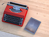 Digitale Illustration einer alten Schreibmaschine und eines modernen Tablet-Computers auf einem Holztisch