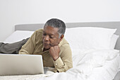 Man with Laptop on Bed