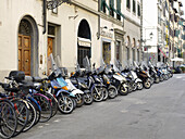 Motorroller und Fahrräder auf der Straße, Florenz, Italien