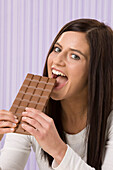 Frau isst Schokoladenriegel