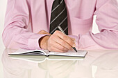 Close-up of Businessman Writing in Appointment Book