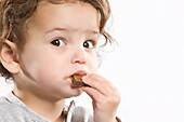 Kleines Mädchen isst Schokolade
