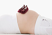 Baby Shoes on Pregnant Woman's Belly