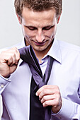 Businessman Putting on Tie