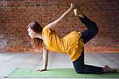 Frau im Yoga-Kurs in der Tiger-Pose