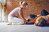 Frauen in der Yogaklasse mit Lehrer