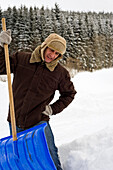 Mann beim Schneeschaufeln, Hof bei Salzburg, Österreich