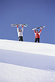 Zwei Snowboarder auf einem Berg stehend, Schweiz