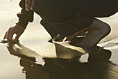 Woman Picking Something out of Sand