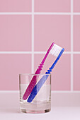 Zwei Zahnbürsten in einem Glas im Waschraum