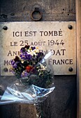 Gedenktafel für einen Franzosen, der am Tag der Befreiung 1944 erschossen wurde, Paris, Frankreich; Blumenstrauß vor einer Gedenktafel