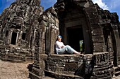 Tourist außerhalb des Bayon-Tempels in der antiken Stadt Angkor; Angkor Wat, Siem Reap, Kambodscha