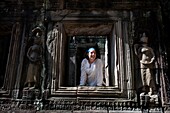 Tourist schaut durch das Tempelfenster in der alten Stadt Angkor; Angkor Wat, Siem Reap, Kambodscha