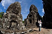 Tourist In The Ruins Of Bayon Temple In Ancient City Of Angkor; Angkor Wat, Siem Reap, Cambodia