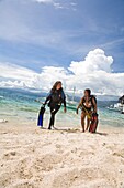 Young Woman With Diving Equipment Walking On Beach; Dumaguete, Oriental Negros Island, Philippines