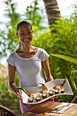 Young Woman Holding Plate Of Sushi, Portrait; Dumaguete, Oriental Negros Island, Philippines