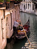 Couple In Gondola On Canal, Rear View; Venice, Italy