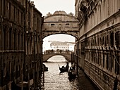 Gondeln, die unter der Seufzerbrücke hindurchfahren; Venedig, Italien