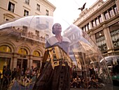 Woman Standing Inside Transparent Glass Globe And Crowd Watching Her Performance; Rome, Italy