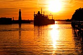 Buffalo-Leuchtturm und Zementtransporter im Hafen von Buffalo bei Sonnenuntergang; Buffalo, New York State, USA