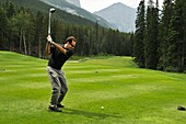 Mittlerer Erwachsener Mann beim Golfspielen; Canmore, Albertas Rockies, Alberta, Kanada