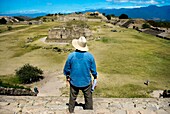 Erhöhte Rückansicht eines Mannes, der alte Maya-Ruinen beobachtet; Mexiko