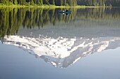 Mann auf Boot, Mt. Hood spiegelt sich im Trillium Lake; Mt Hood National Forest, Oregon, USA