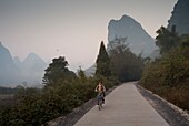 Young Woman Riding Bike In Mountain Area