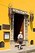 Antigua, Guatemala, Mittelamerika; Mann geht an einem Restaurant im Kolonialstil vorbei