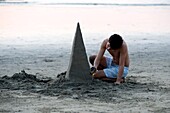 Puerto Vallarta, Mexico; Young Man Building Sand Sculpture