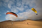 Fünf Personen beim Parasailing und der Landung in der Wüste; Iquique, Chile