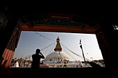 Man Taking A Picture Of Boudhanath Stupa Through A Window
