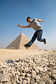 Man Jumping In Air With Pyramid In Background