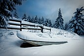 Kleines Boot an einem Zaun im Winter