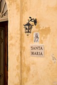A Front Door Beside A Light And A Santa Maria Sign