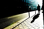 Silhouette und Schatten einer Person, die auf dem Bürgersteig geht, Paris, Frankreich
