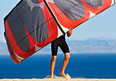 Mann hält Drachen zum Surfen; Costa De La Luz, Andalusien, Spanien
