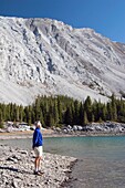 Man Standing By A Mountain Lake