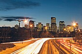 Calgary, Alberta, Canada; Skyline At Night With Car Lights On The Road