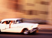 Menschen fahren ein klassisches amerikanisches Auto in Havanna, unscharfe Bewegung