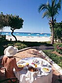 Touristin frühstückt draußen am Strand
