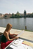 Frau liest Speisekarte in einem Café nahe der Karlsbrücke