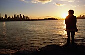 Frau beobachtet den Sonnenuntergang im Hafen von Sydney