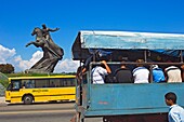 Ein Lastwagen mit Menschen neben der Statue von Antonio Maceo auf der Plaza De La Revolucion.