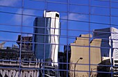 Wolkenkratzer spiegeln sich in einem modernen Glasgebäude