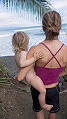 Mutter hält Kind am Strand