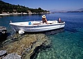 Frau in einem Boot nahe der Küste, Korfu