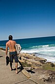 Männlicher Surfer auf dem Weg zwischen Bondi Beach und Bronte Beach